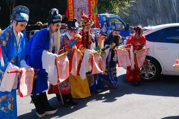 People in ceremonial costumes bowing near 7-11