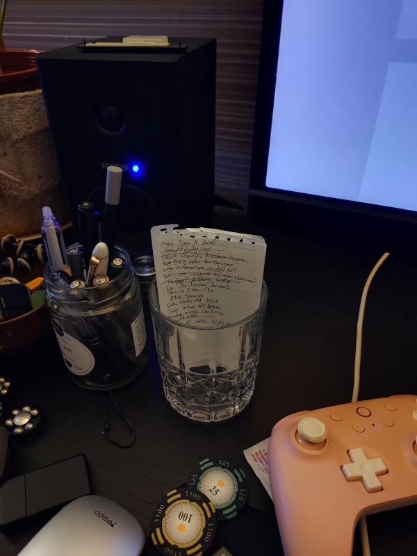 Paper notes in a glass jar on a desk