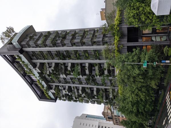 A building in Taiwan with many plants on the balconies.