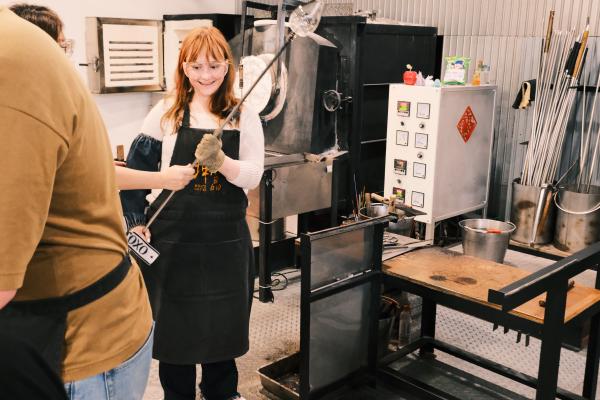 Colette holding the glass blowy tube thing