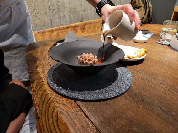 Chocolate sauce being added to the first dessert