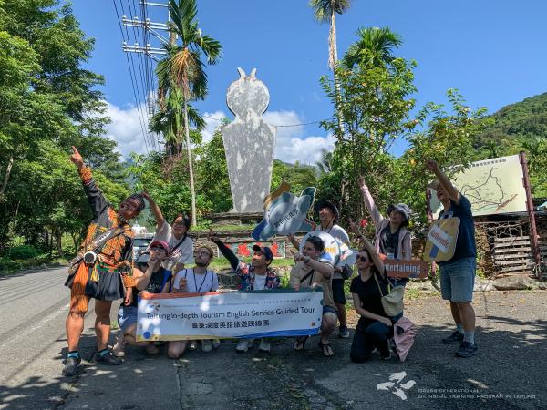 The group posing with a banner near the tribe entrance