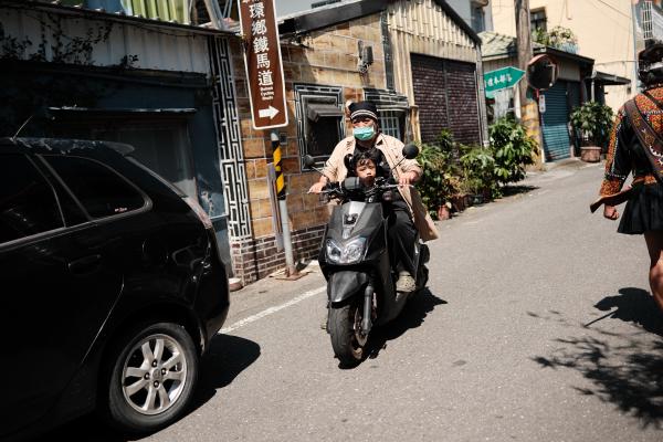 A man and kid on a scooter