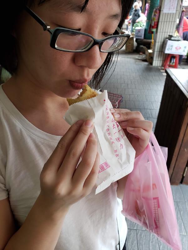 Fried bun filled with meat being eaten by Tammy