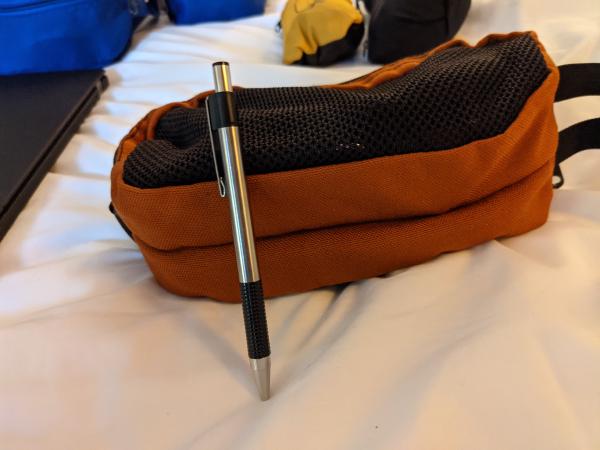 My electronics, packed into the Tom Bihn Snakecharmer, with pen for scale.